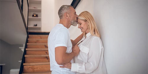 Older black woman relaxing on couch in sunlit living room captur